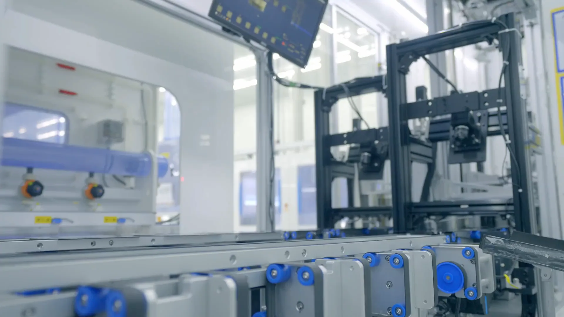 Footage of a production line, a highway interchange and a wind farm over farmland.